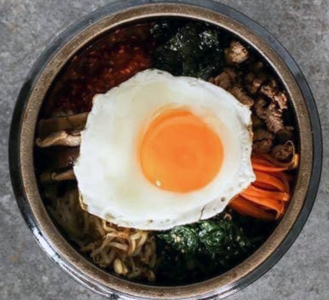 Korean bibimap served in a steel bowl, topped with a fried egg