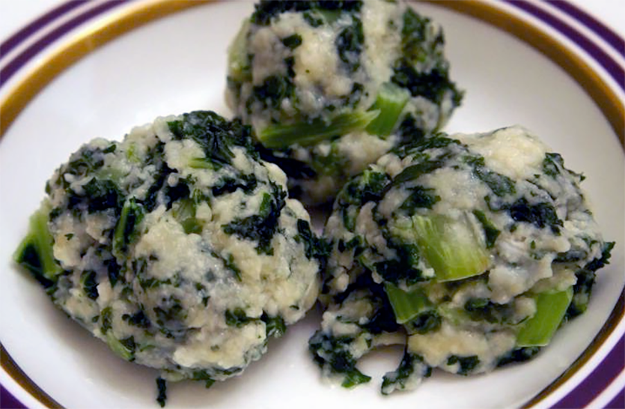 mix roasted vegetables on a white plate with a spoon
