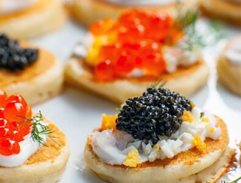 buckwheat blinis served topped with black caviar and salmon roe