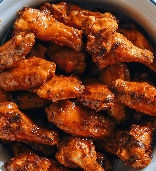 cooked buffalo wing pieces piled in a bowl