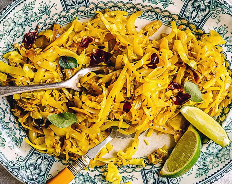 cabbage mallung served on a plate with lime wedges