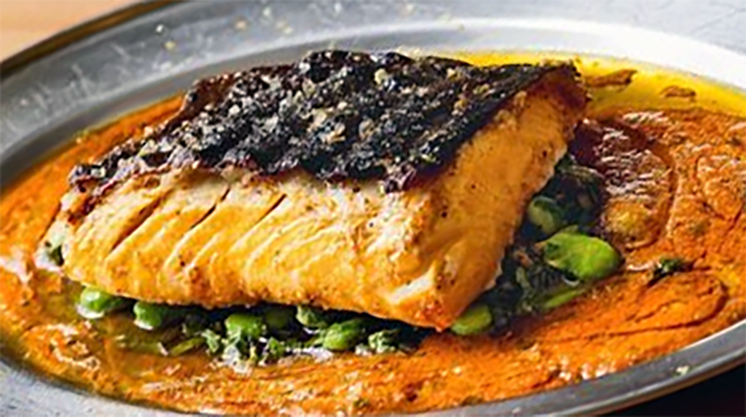 fish steak on a bed of onion, piri-piri and red oil sauce