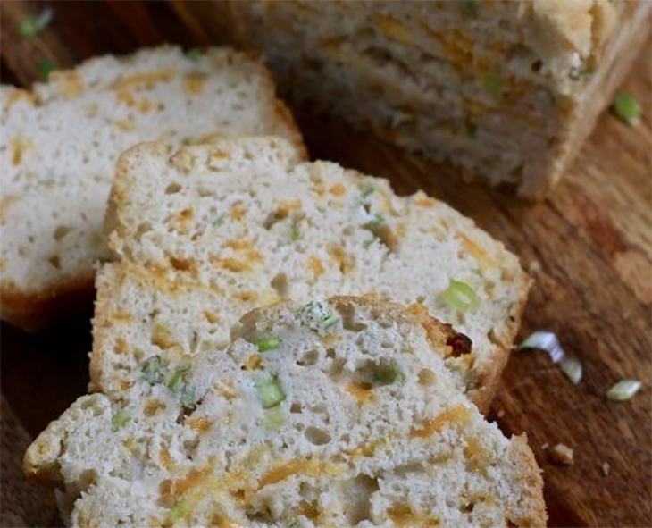 Cheddar and onion beer bread sliced on a chopping board