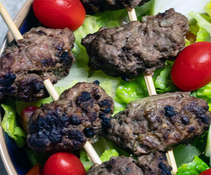 barbecued beef strips barbecued on skewers and served with a salad