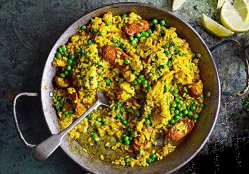 chicken and chorizo paella with peas in a paella pan