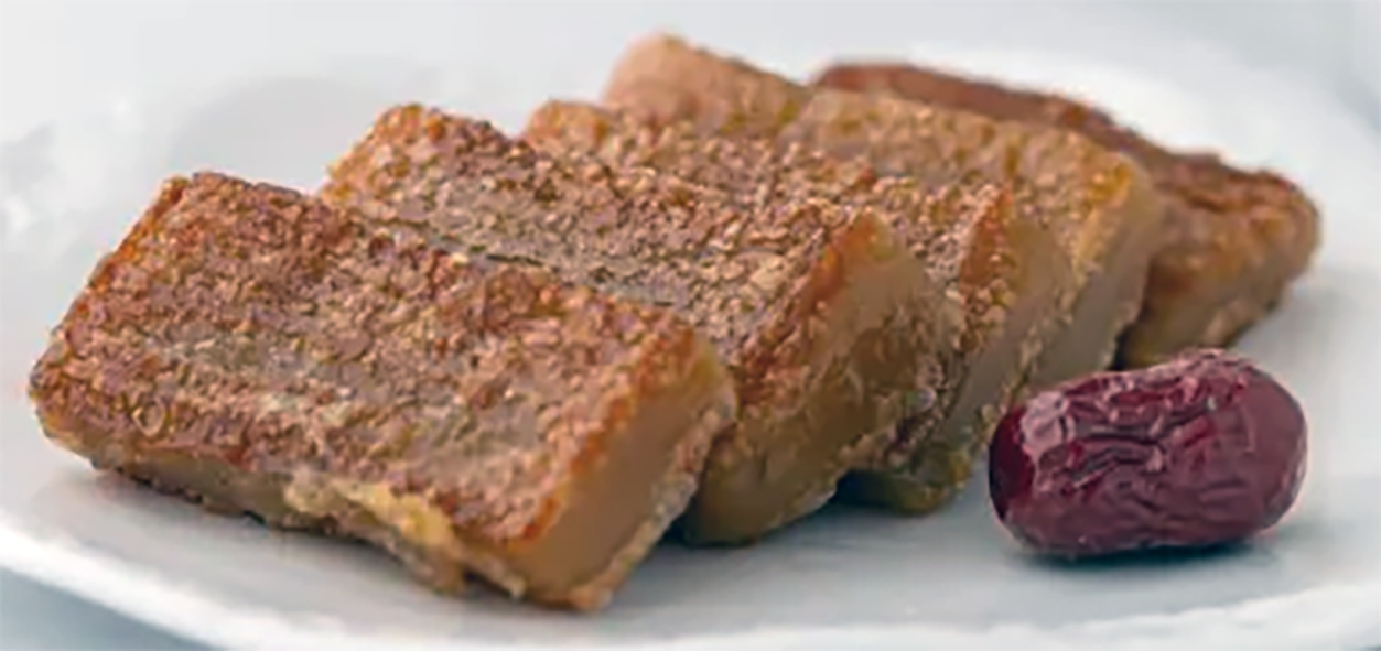 slices of nian gao on a white plate next to a date
