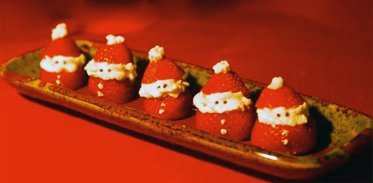 strawberries decorated like little santas on a serving dish