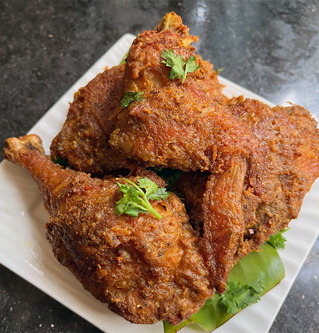 five pieces of Cocos Islands Ayam Goreng piled on a plate