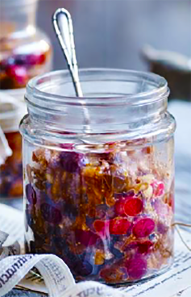 cranberry, fig and almond mincemeat in a glass jar with a teaspoon