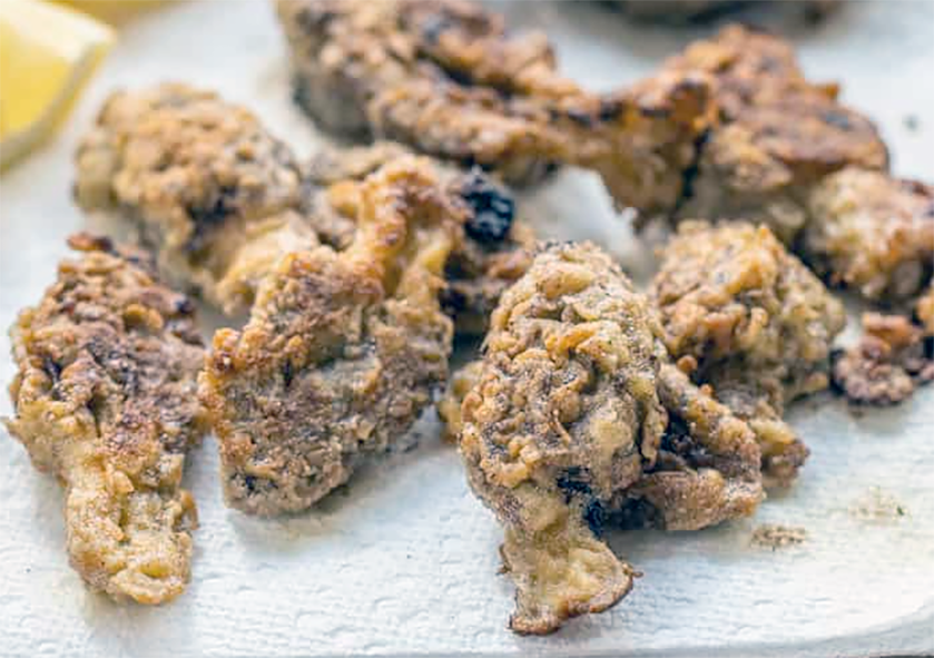 crisp-fried morels with a seasoned flour coating on kitchen paper