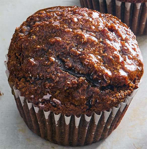 Date and bran muffin in a paper case on a marble work top