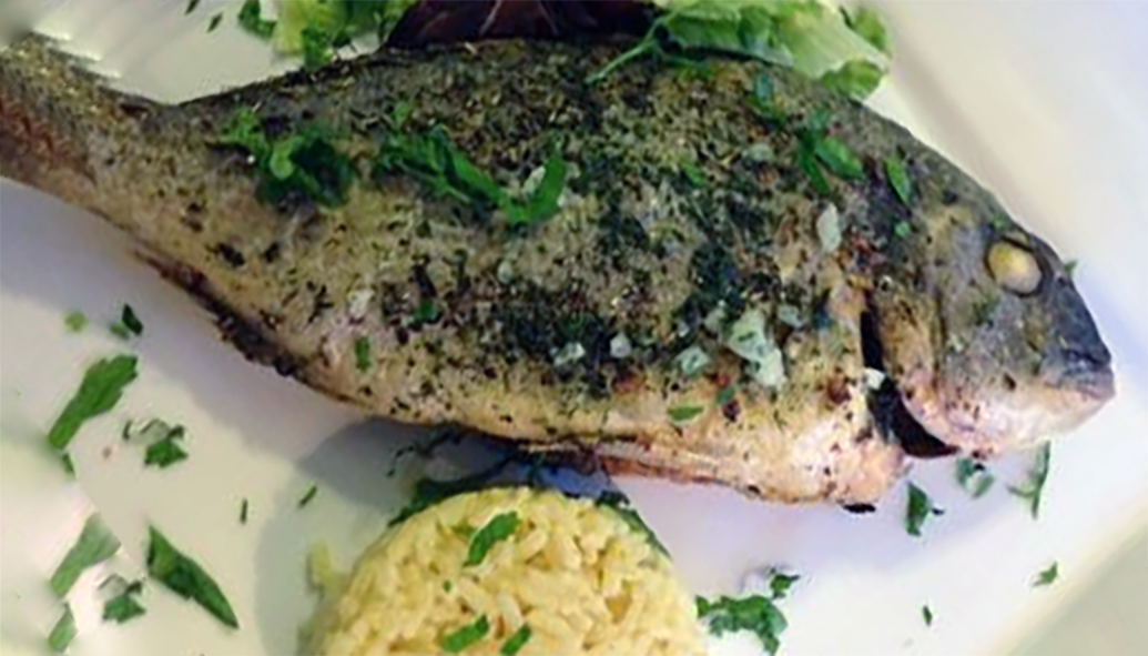 barbecued herbed sea bream served on a plate with rice
