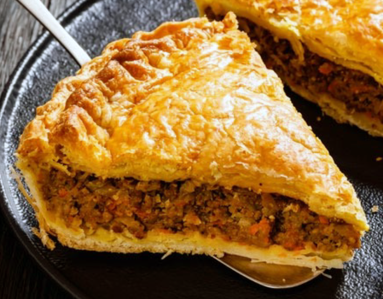 Wedge of Dingle pie, showing the meat filling sitting on a cake slice