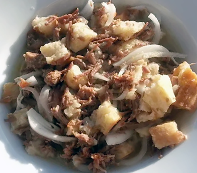 Bowl of dograma, meat, bread and onions in mutton and tomato stock