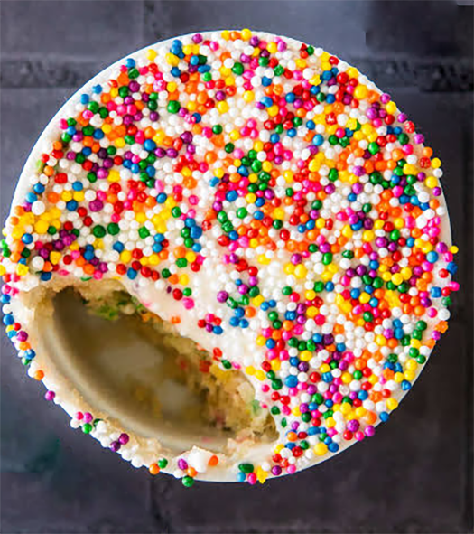 sprinkle-topped dot cake in a ramekin with a spoonful removed