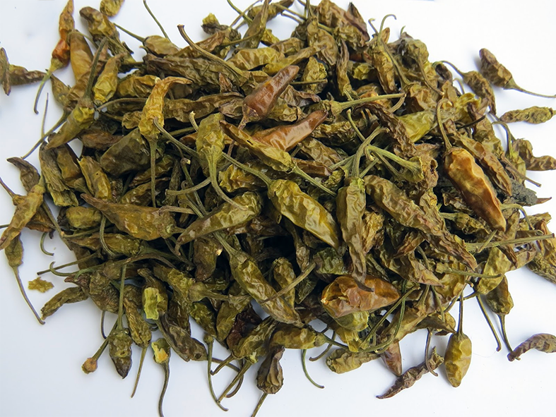 air-dried green chillies against a white background