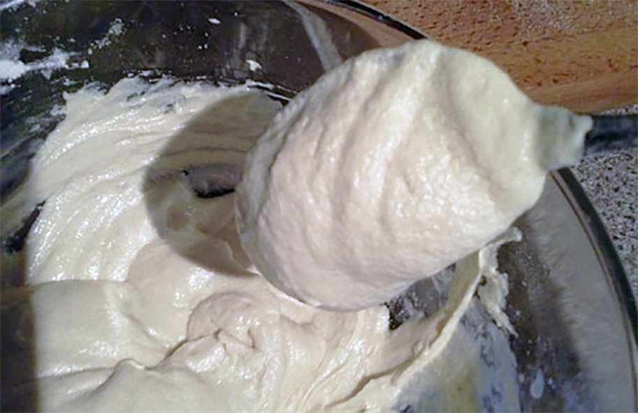 Dropping consistency cake batter on a wooden spoon