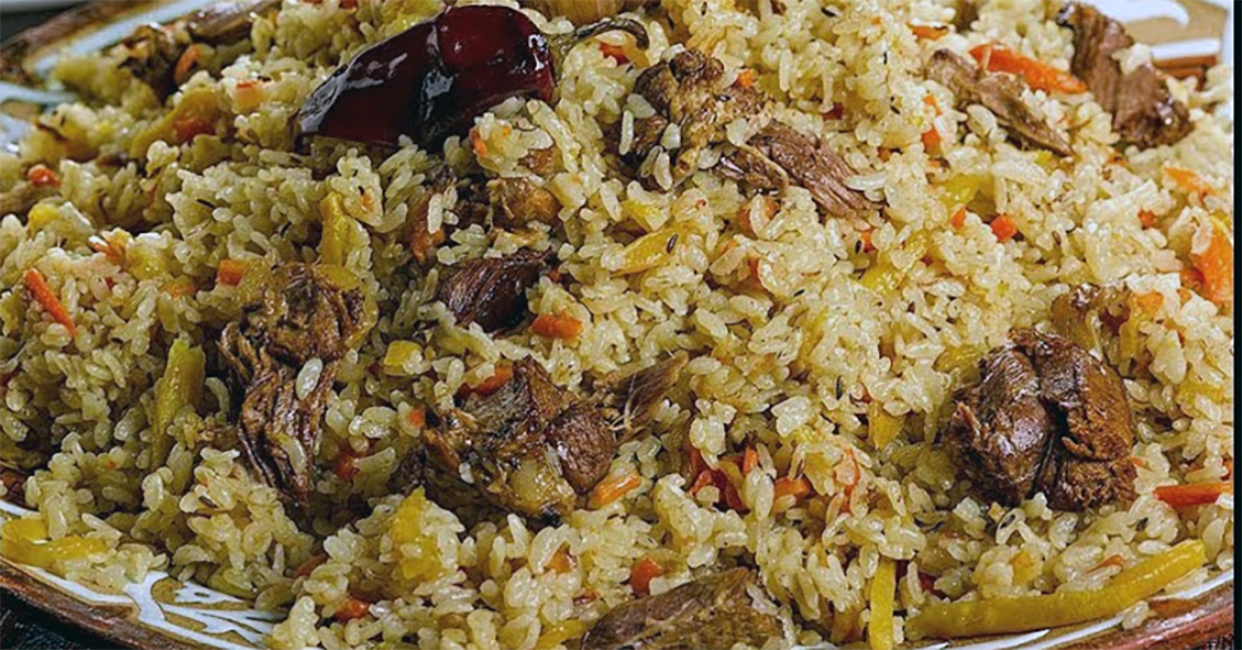 duck and rice pilau served on a plate and garnished with a dried chillie
