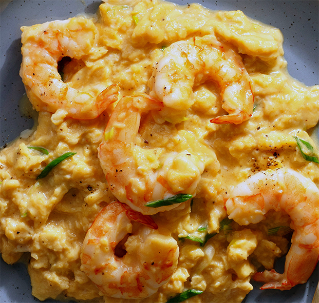 scrambled eggs with prawns served over a slice of toast