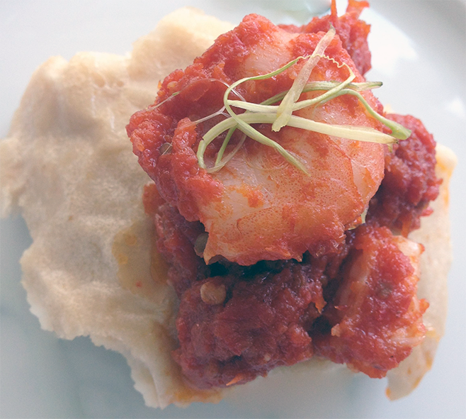 ehuru arranged on a plate with tomato ata sauce spooned over the top