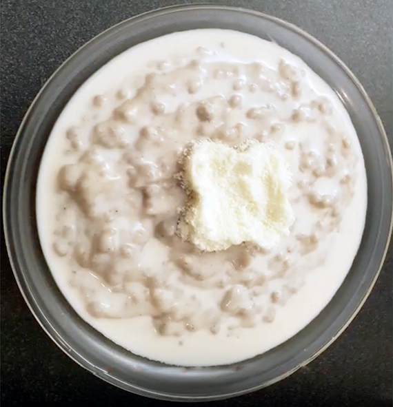 millet porridge served in a glass bowl with a cottage cheese garnish