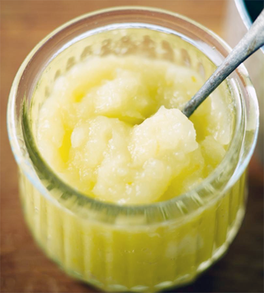 apple sauce presented in a glass ramekin with a spoon
