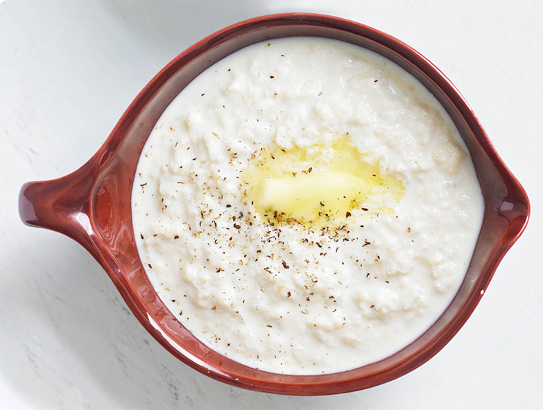 Bread sauce in a brown sauce boat with a garnish of melted butter