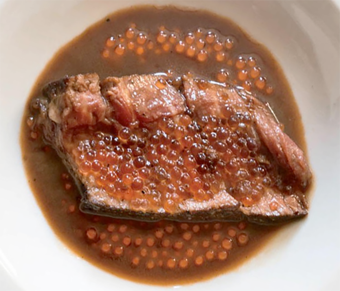 slice of steak with truffle spheres served in a bowl with financiere sauce