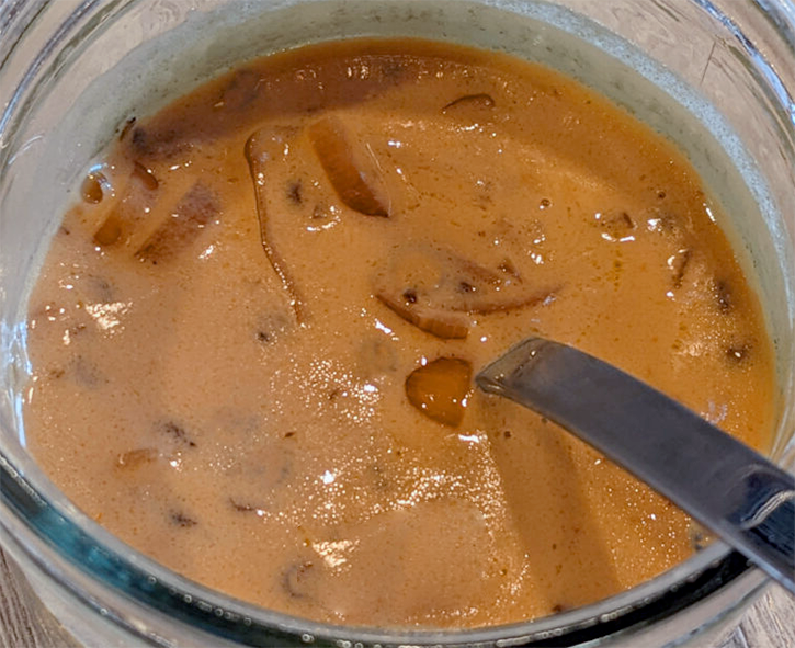 Lyonnaise sauce in a glass bowl with a spoon