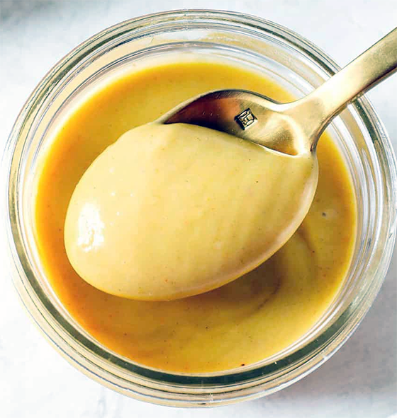 Mustard sauce with spoon presented in a glass jar