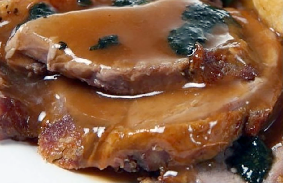 two slices of beef topped with perigeux sauce with the pieces of truffle visible