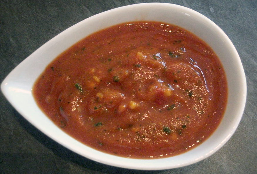 Provençale sauce in a white teardrop-shaped sauce dish