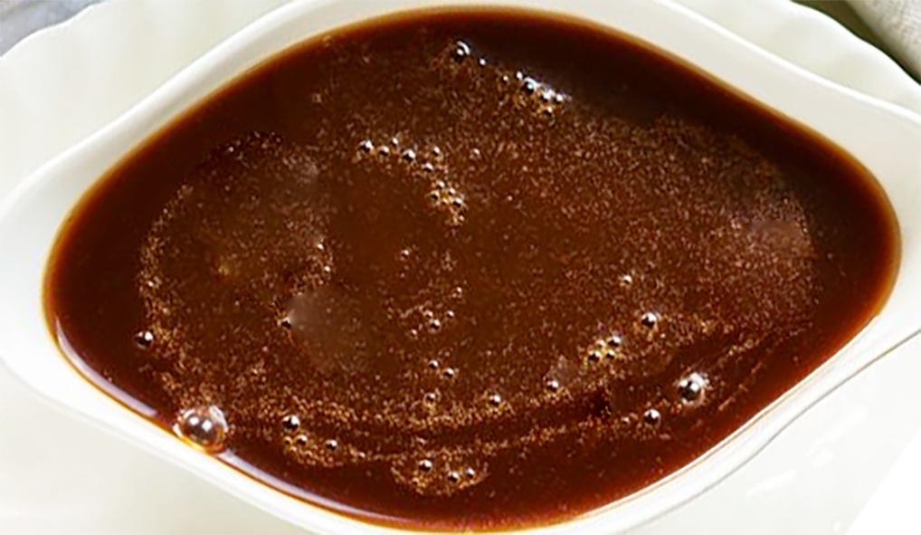 brown truffle sauce in a white oval sauce dish