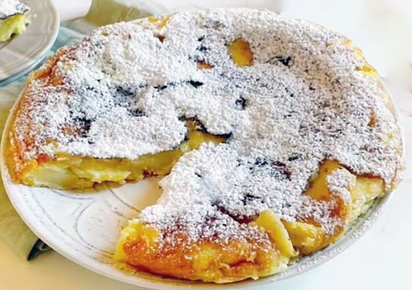 baked friar's omelette turned out onto a plate, dusted with icing sugar and with a wedge removed