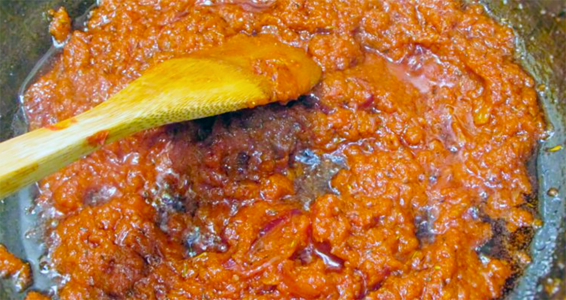 ata sauce frying in pan stirred with a wooden spoon