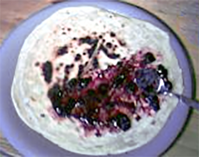 Stack of gambir sweet flatbreads on a plate, the top flatbread spread with jam