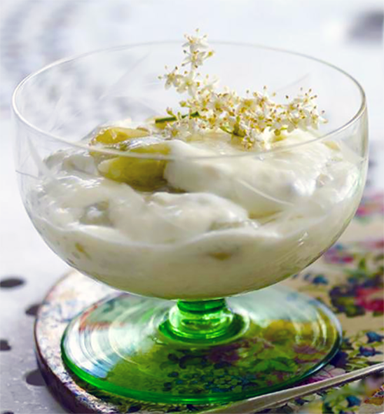 gooseberry and elderflower custard garnished with elderberry flowers in a glass dessert dish