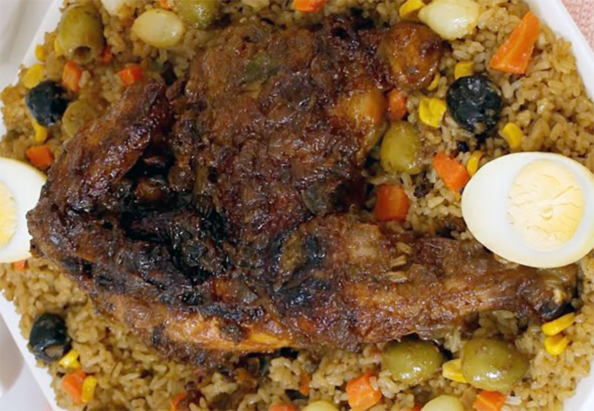 Senegalese guinaar fried chicken served with rice and olives and a halved hard-boiled egg