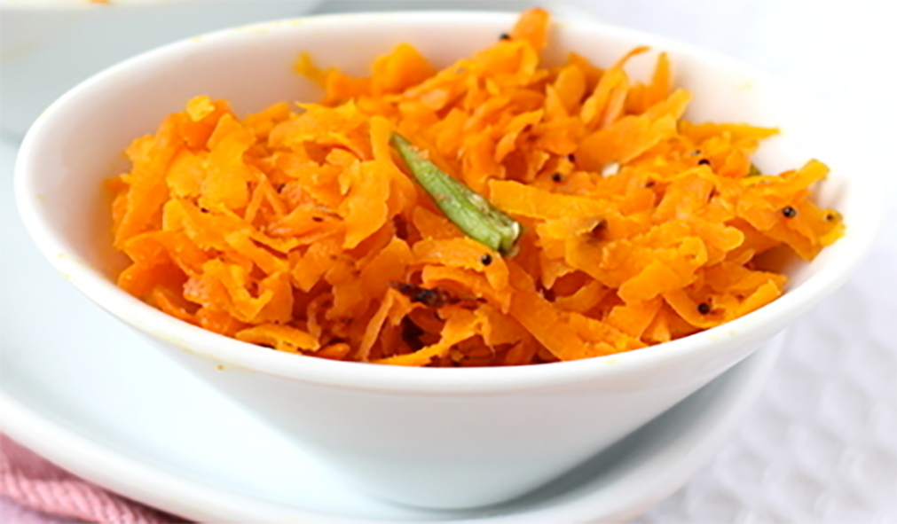 salad of grated carrot topped with a liver of chilli served in a white bowl