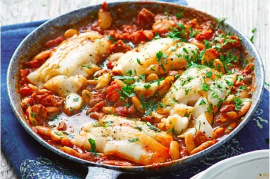 hake and chorizo stew cooked in a steel frying pan