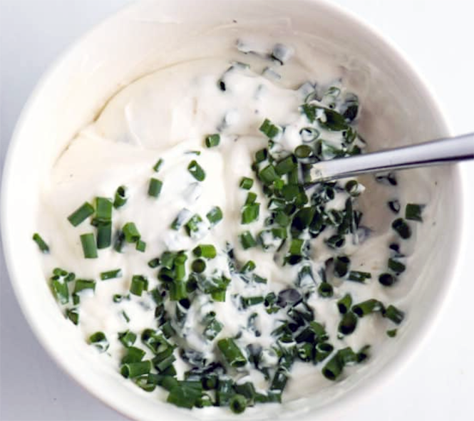 herbed horseradish yoghurt dressing in a bowl with a spoon