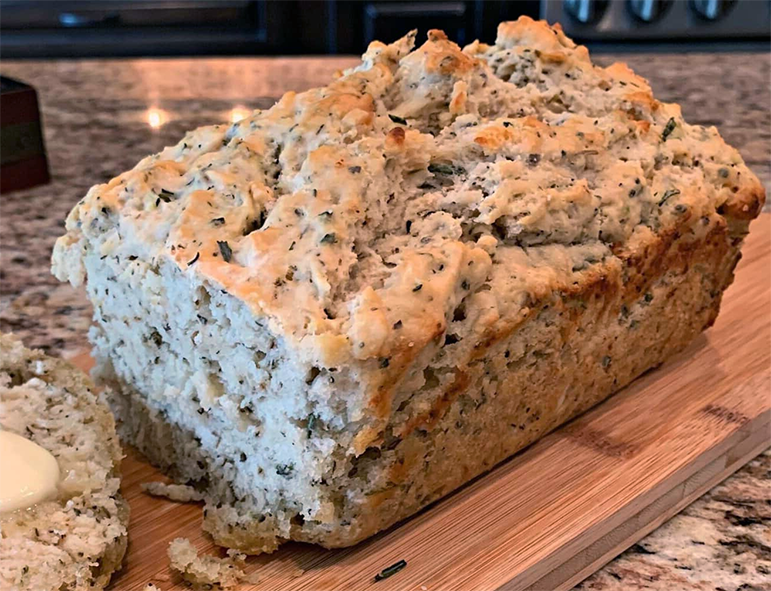 herbed beer bread sliced on a chopping board