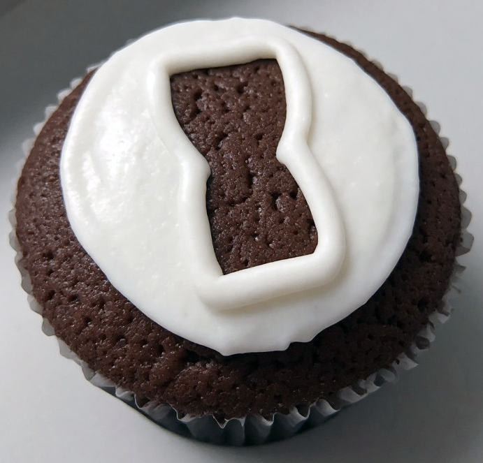 Chocolate cupcake with whisky topped with fondant icing and decorated with a chocolate hourglass picked out with icing