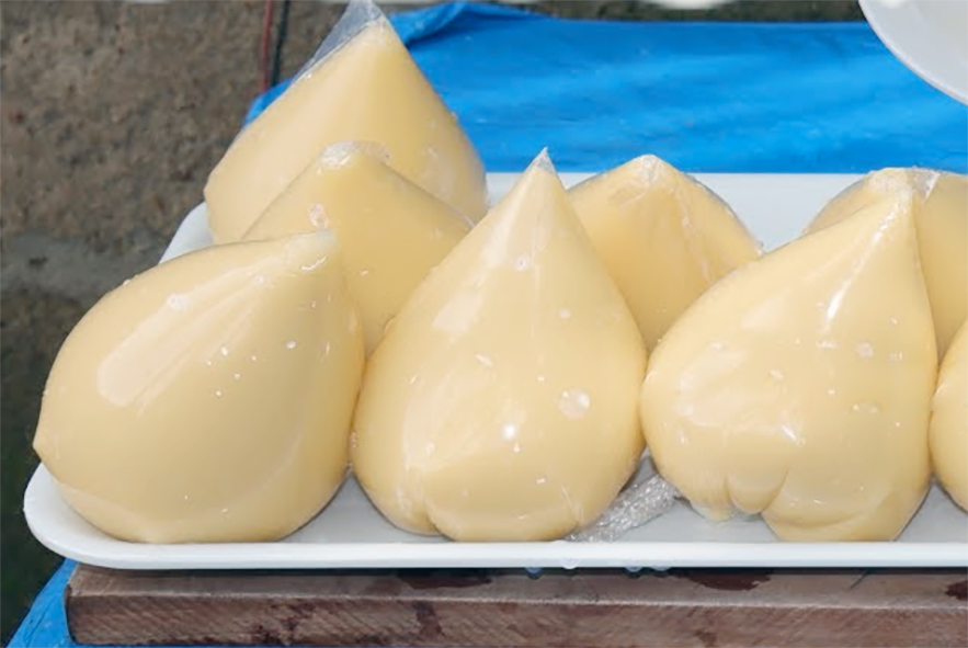 eko cooked in a plastic bag arranged on a rectangular plate against a blue background