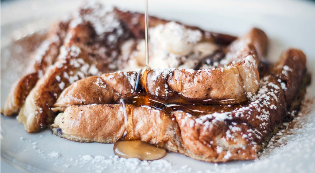 slices of irish soda bread french toast garnished with icing sugar and drizzled with honey