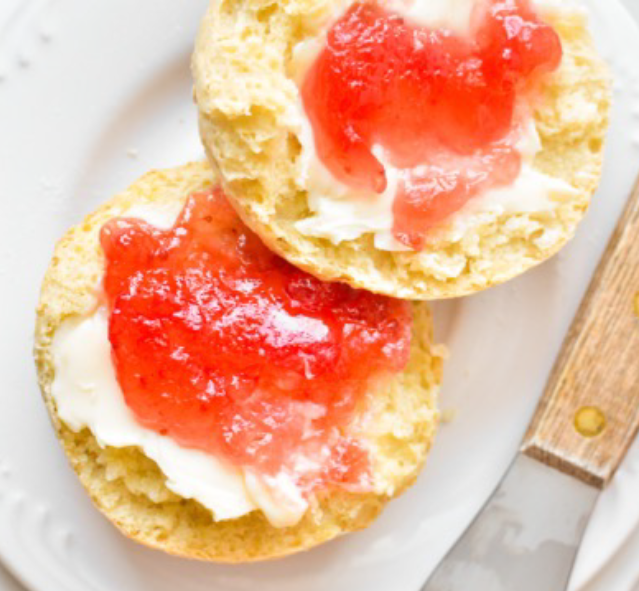 split irish soda scones on a plate with clotted cream and raspberry jelly
