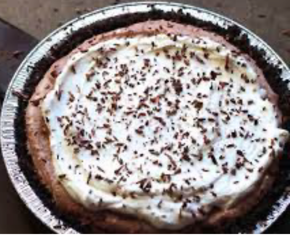 Irish whiskey cream pie in a foil dish topped with whipped cream and garnished with chocolate shavings