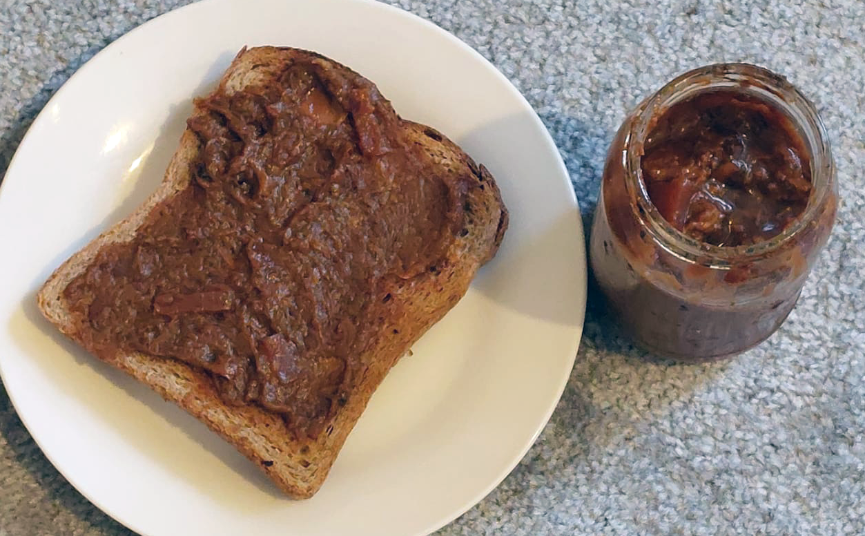 Japanese knotweed and pineapple marmalade in a jar next to a plate with the marmalade spread on toast
