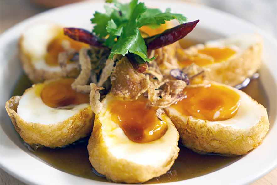 halved son in law eggs (kai look koei) served in a shallow dish