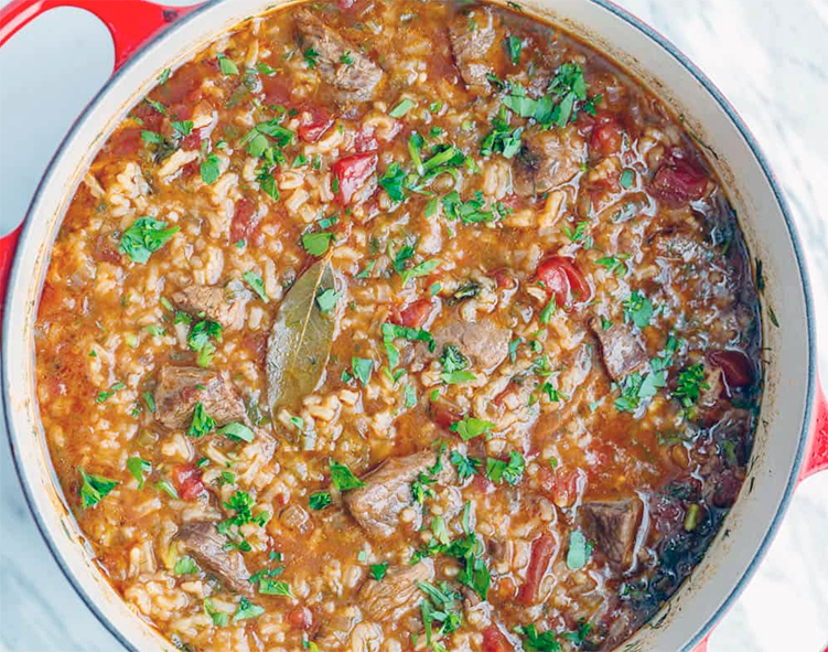 kharcho soup in a cast iron casserole (Dutch oven) garnished with a bay leaf
